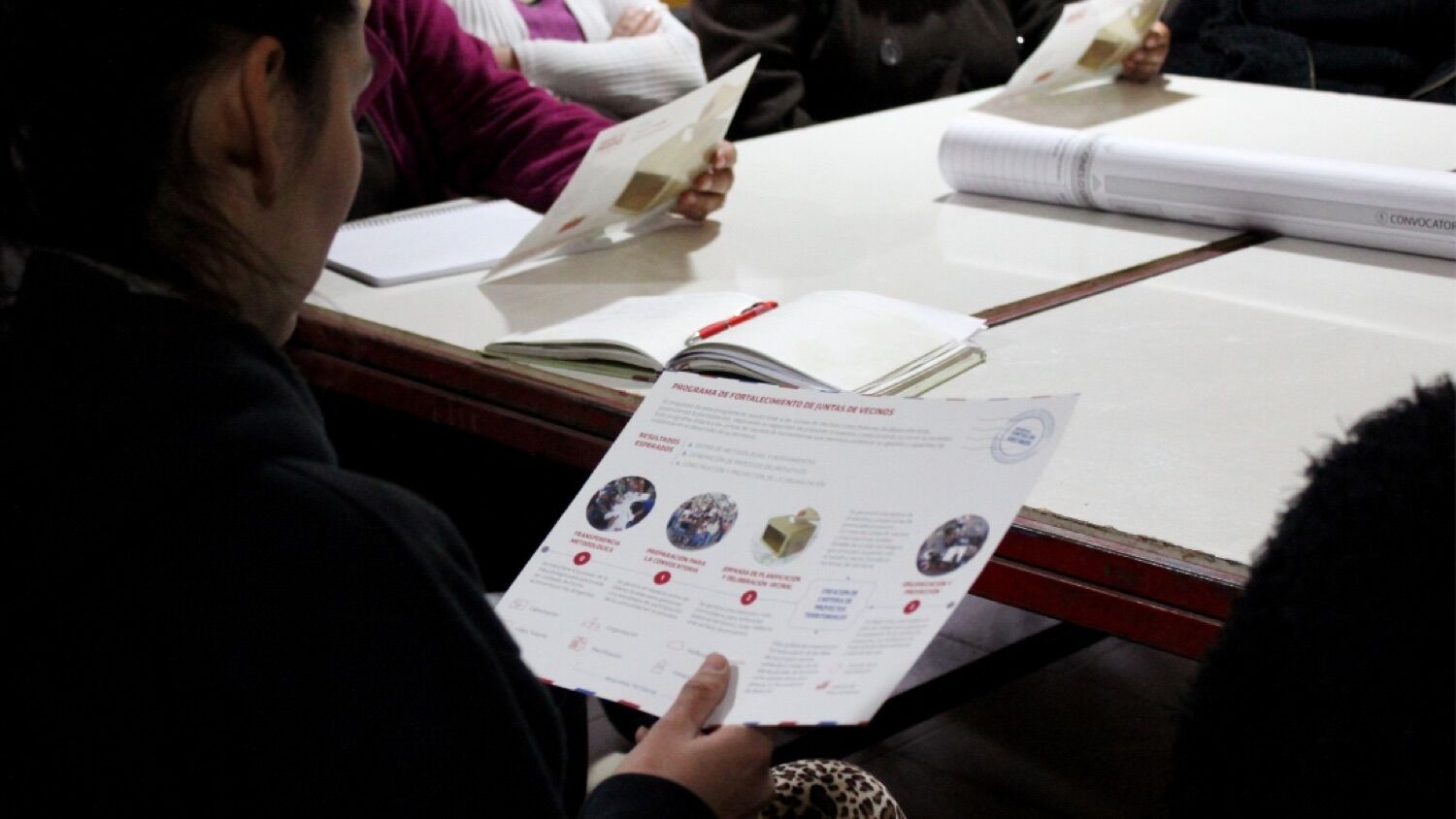 Reunión comunitaria con material de un programa