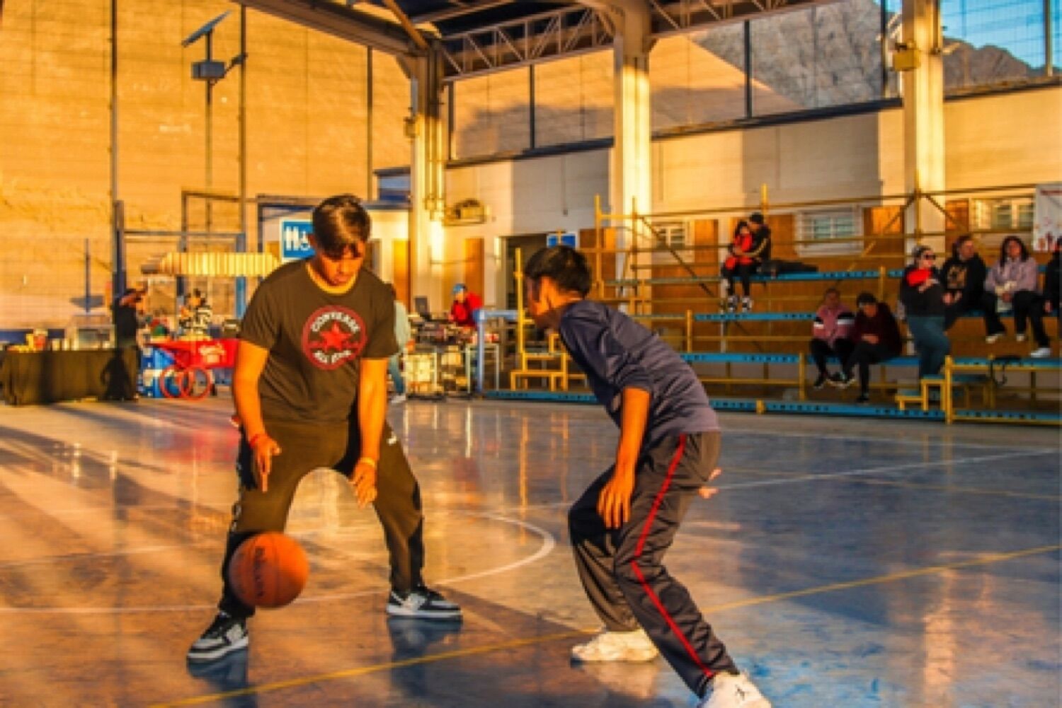 Jóvenes jugando básquetbol en un gimnasio comunitario